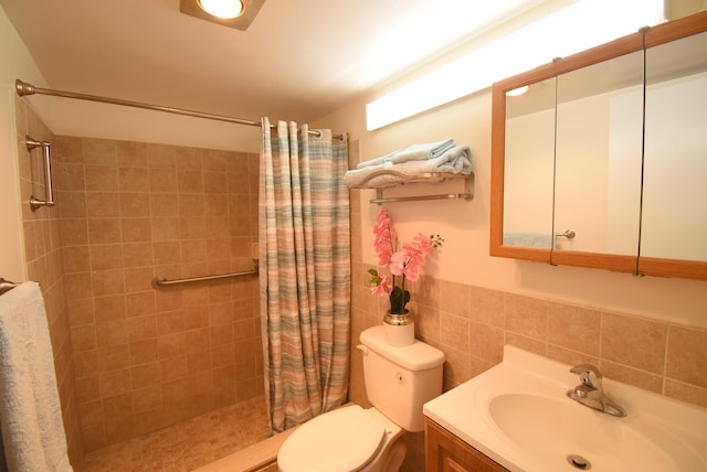 bathroom featuring vanity, toilet, tile walls, and walk in shower