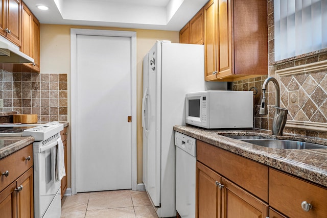 kitchen with tasteful backsplash, sink, light tile patterned floors, and white appliances