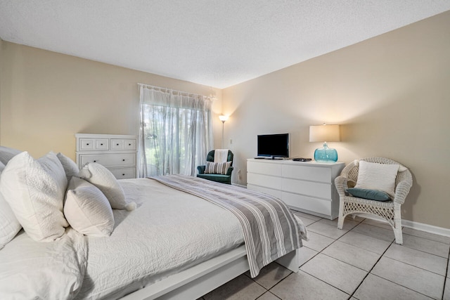 bedroom featuring light tile patterned floors and a textured ceiling