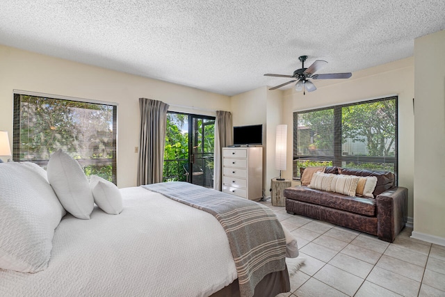 tiled bedroom featuring ceiling fan, a textured ceiling, and access to outside