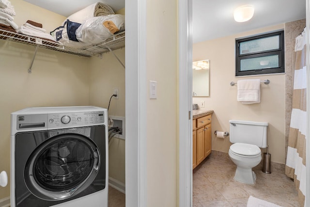 laundry area with washer / clothes dryer and light tile patterned floors