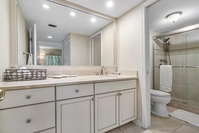 bathroom with vanity, toilet, tile patterned floors, and walk in shower