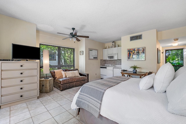 bedroom featuring a textured ceiling, ceiling fan, and light tile patterned flooring