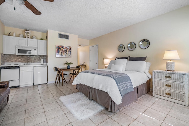 tiled bedroom featuring ceiling fan, sink, and a textured ceiling