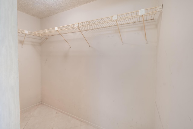 spacious closet with light tile patterned floors