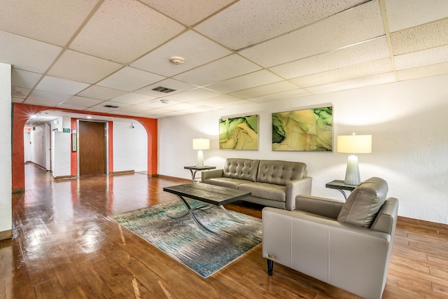 living room with a drop ceiling and hardwood / wood-style floors