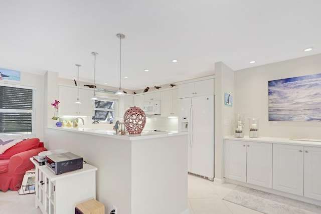 kitchen featuring light tile patterned flooring, white cabinetry, hanging light fixtures, kitchen peninsula, and white appliances