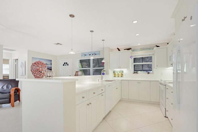 kitchen with sink, white appliances, hanging light fixtures, and white cabinets