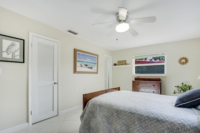 bedroom with light tile patterned floors, a closet, and ceiling fan