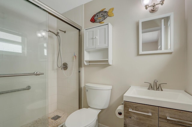 bathroom with vanity, toilet, and a shower with shower door