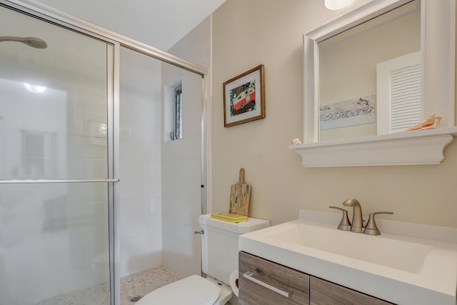 bathroom with vanity, toilet, and a shower with door