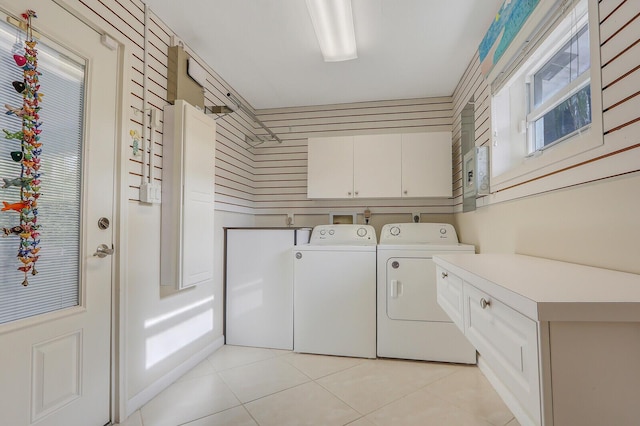 laundry room with cabinets, light tile patterned floors, and washing machine and clothes dryer