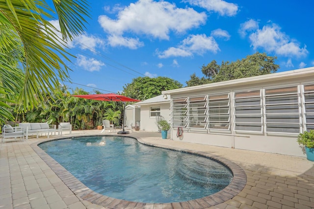 view of swimming pool featuring a patio and a shed