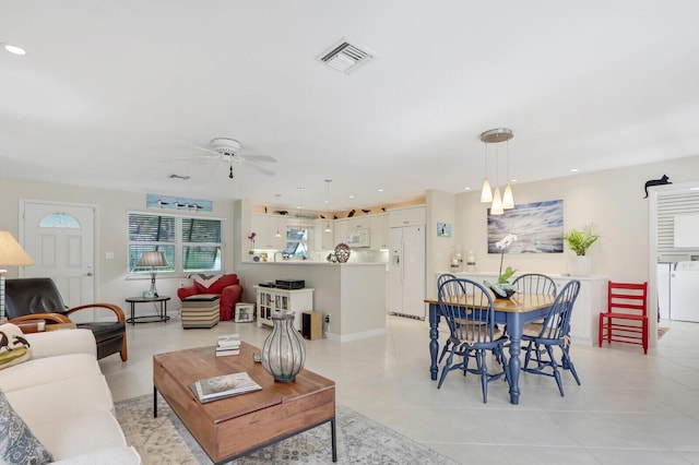 tiled living room with washer / dryer and ceiling fan