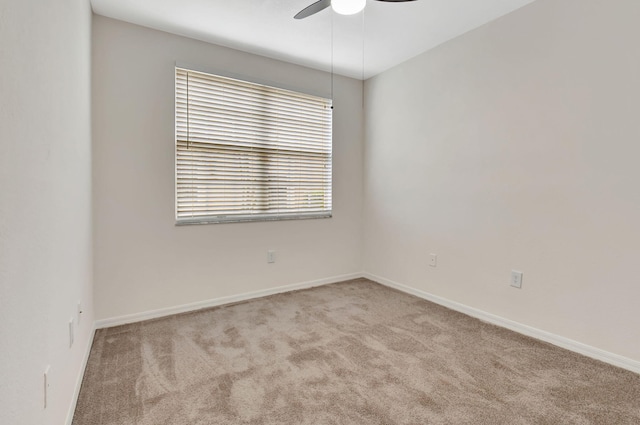 spare room with light colored carpet and ceiling fan