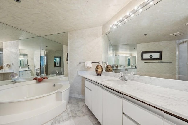 bathroom with vanity, shower with separate bathtub, and tile walls