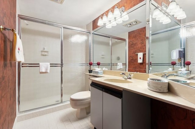 bathroom featuring vanity, tile patterned floors, toilet, and walk in shower