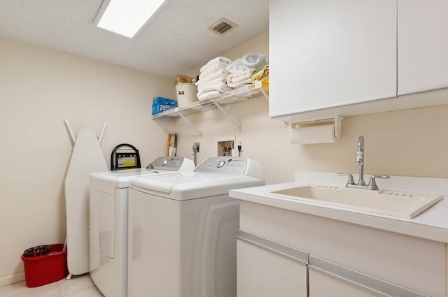 laundry room with cabinets, washing machine and dryer, sink, and light tile patterned flooring