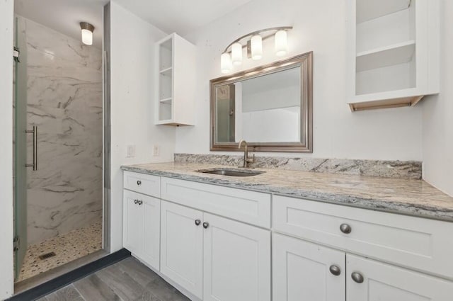 bathroom featuring vanity, a shower with shower door, and wood-type flooring