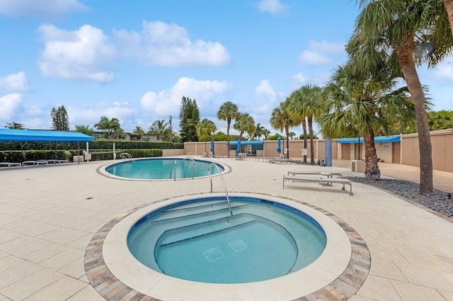 view of swimming pool featuring a community hot tub and a patio area