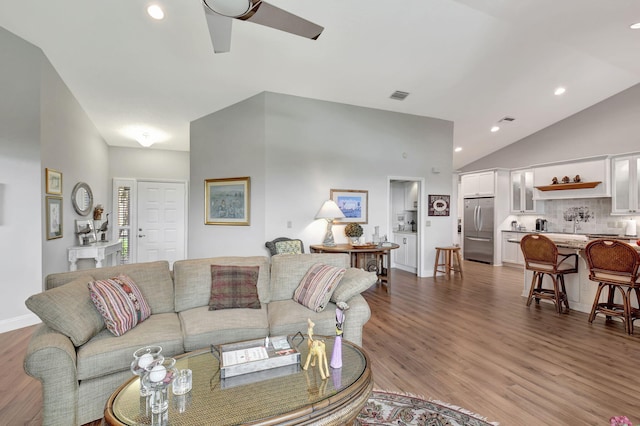 living room with wood-type flooring, lofted ceiling, and ceiling fan