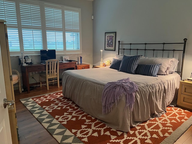 bedroom with dark hardwood / wood-style flooring