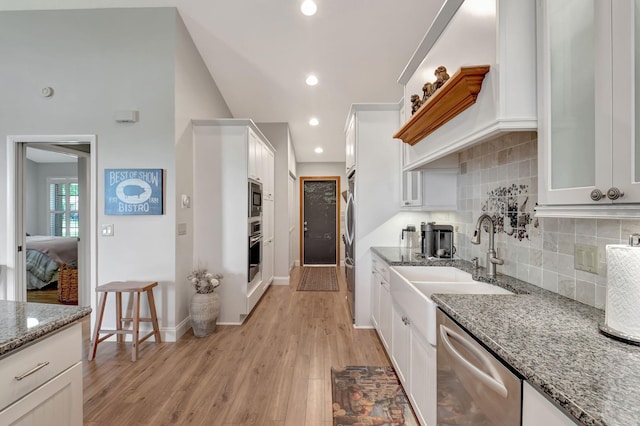 kitchen with sink, white cabinetry, light stone counters, stainless steel appliances, and backsplash