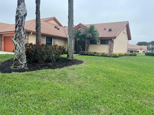 view of front of property featuring a garage and a front lawn