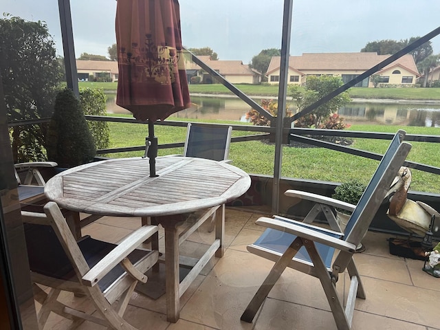 sunroom / solarium featuring a water view