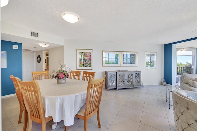 tiled dining room with ceiling fan and a textured ceiling