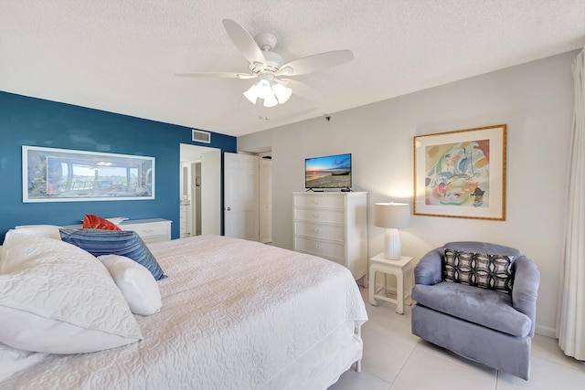 tiled bedroom featuring ceiling fan and a textured ceiling