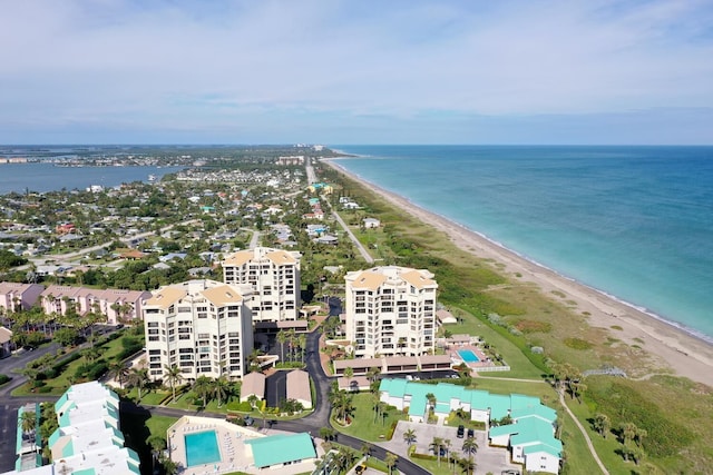 birds eye view of property featuring a beach view and a water view