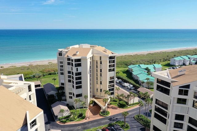 drone / aerial view with a water view and a beach view