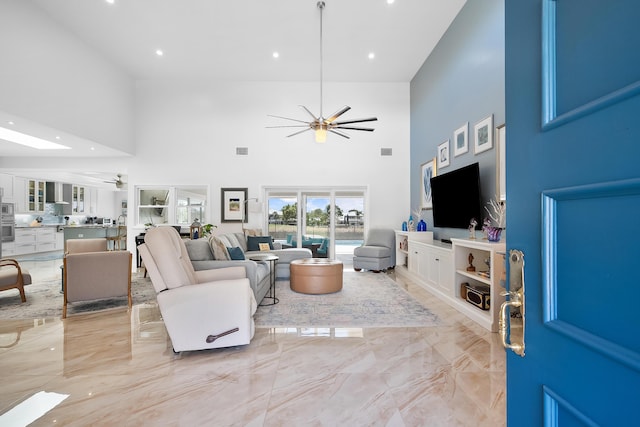 living room with ceiling fan and a high ceiling