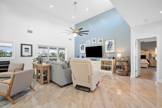 living room with ceiling fan, a healthy amount of sunlight, and high vaulted ceiling