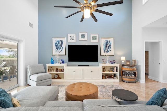 living room with a towering ceiling and ceiling fan