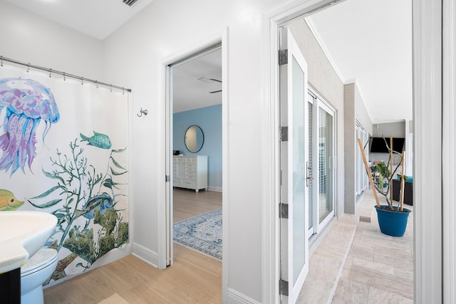 bathroom featuring hardwood / wood-style flooring, toilet, and french doors