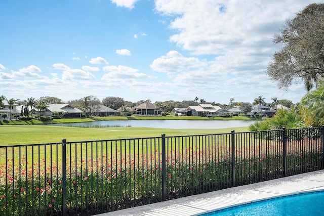 view of pool featuring a water view and a lawn