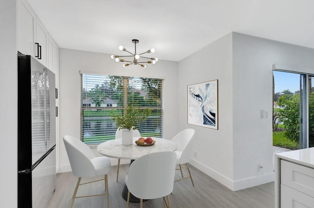 dining space featuring light wood-type flooring and a chandelier