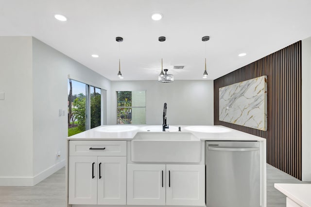 kitchen featuring sink, white cabinetry, decorative light fixtures, dishwasher, and light hardwood / wood-style floors