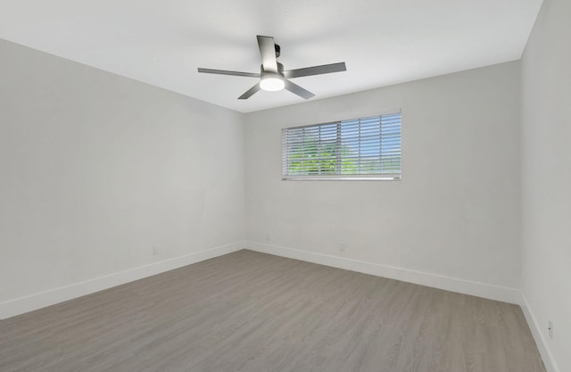 empty room with ceiling fan and light hardwood / wood-style flooring