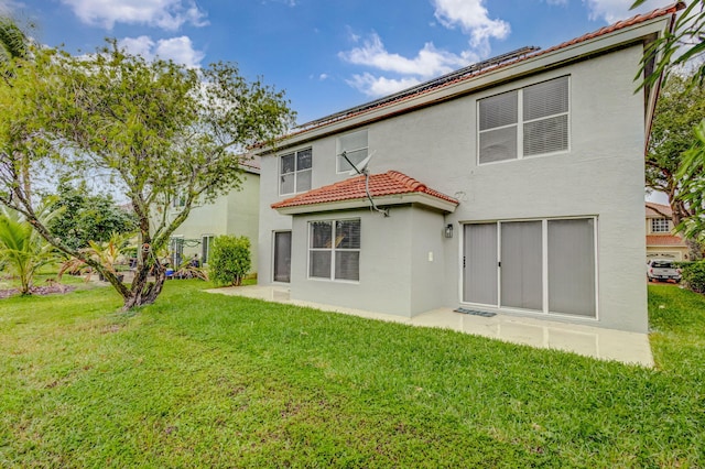 rear view of property featuring a patio area and a lawn