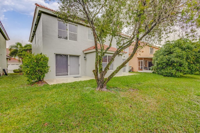 back of house with a yard and a patio