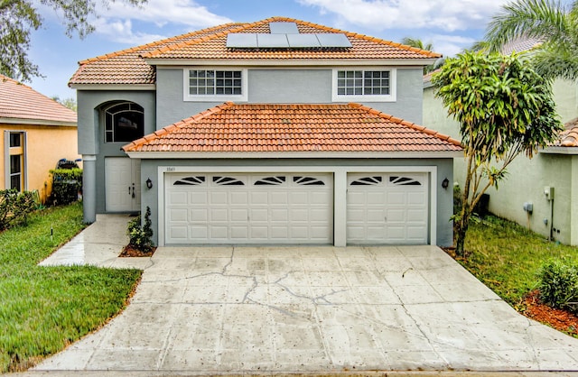 mediterranean / spanish-style home featuring a garage and solar panels