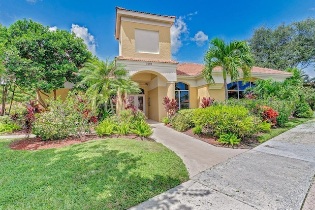 mediterranean / spanish house featuring a front lawn