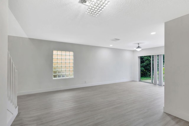 unfurnished room featuring light hardwood / wood-style flooring and a textured ceiling