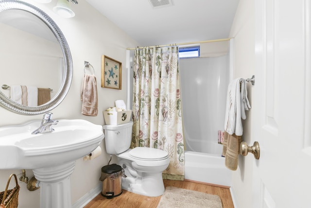 bathroom with hardwood / wood-style flooring, toilet, and shower / bath combo