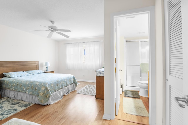 bedroom with ceiling fan, connected bathroom, hardwood / wood-style floors, and a textured ceiling