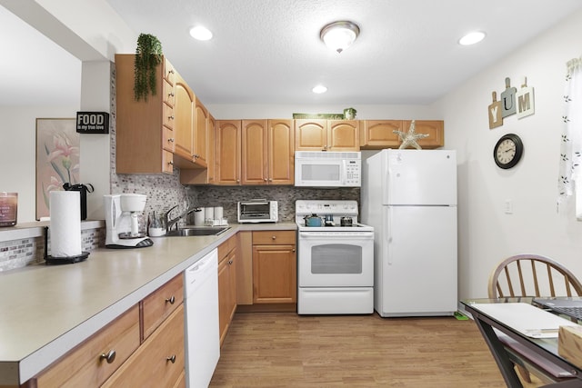 kitchen with sink, decorative backsplash, white appliances, a textured ceiling, and light wood-type flooring