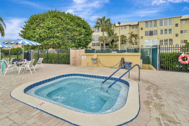 view of pool with a hot tub and a patio area